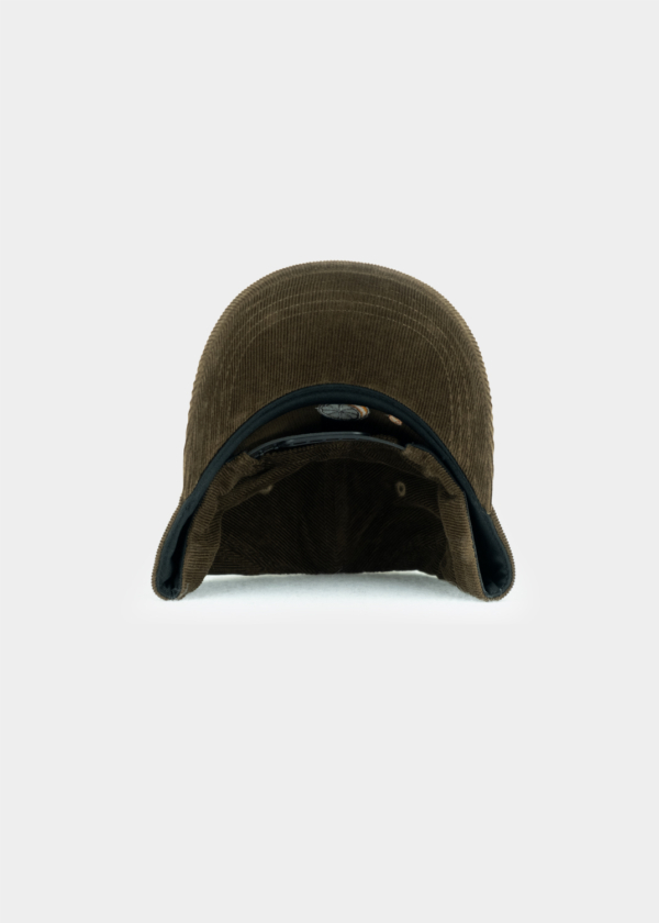 Frontale Unteransicht der brauen "Bazi"-Cord-Cap. Zu sehen ist die gebogene Schirmunterseite sowie das Innenfutter der Kappe mit einem verstellbaren Verschluss.